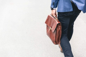 Man walking with briefcase bag. He provides outsourced cfo services in Fairfield CT. Business consulting and accounting services are available.
